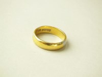 Lot 216 - A 22ct gold plain polished wedding band,...