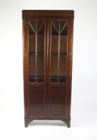 Lot 517 - A 1920s oak cabinet bookcase with two ribbed...